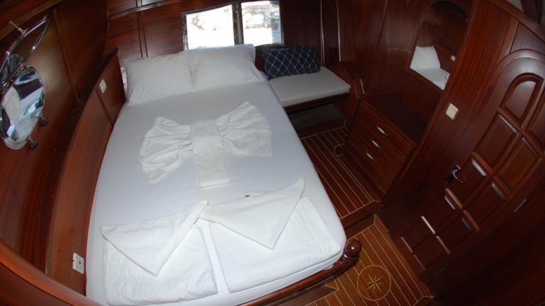 Double bed in the cabin with white linens and towels